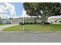 Charming single-story home with well-maintained lawn, mature tree, and inviting curb appeal at 9486 Se 173Rd Pl, Summerfield, FL 34491