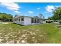 Exterior view of the single-story home, showcasing its well-kept lawn and attached sunroom at 10210 Sw 93Rd Ave, Ocala, FL 34481