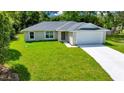 Charming single-story home featuring a well-manicured lawn and a two car garage at 10675 Sw 69Th Ter, Ocala, FL 34476