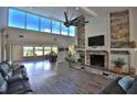 Bright living room featuring a stone fireplace, hardwood floors, and beautiful lake views at 10893 Se 141 Avenue Rd, Ocklawaha, FL 32179