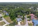 An aerial view of a charming single-story home surrounded by lush trees in a tranquil neighborhood at 11645 Mallard Ct, Dunnellon, FL 34432
