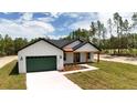 Charming modern farmhouse with green garage door, black trim, and covered porch at 12251 Sw 67Th Ln, Ocala, FL 34481