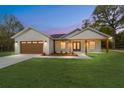 Charming single-story home with a tan garage door and a lovely wood-accented porch at 12251 Sw 67Th Ln, Ocala, FL 34481