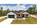 A stunning one-story house with a green garage door and wood porch accents at 12251 Sw 67Th Ln, Ocala, FL 34481