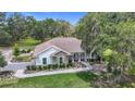 Charming exterior elevation with stone accents, manicured landscaping, walkway and beautiful trees at 15620 Nw 112Th Ave, Reddick, FL 32686