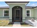 Charming entryway with a screened-in porch, stylish door, and house number display at 15994 Sw 55Th Avenue Rd, Ocala, FL 34473