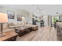 Open-concept living room and kitchen area with hardwood floors and modern lighting fixtures at 15994 Sw 55Th Avenue Rd, Ocala, FL 34473