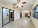 Expansive living area with tiled floors, multiple ceiling fans, and ample natural light from large windows and sliding doors at 16621 Se 57Th Pl, Ocklawaha, FL 32179