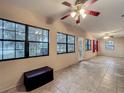 Open living area filled with natural light, featuring tiled flooring and large windows overlooking the serene outdoor landscape at 16621 Se 57Th Pl, Ocklawaha, FL 32179