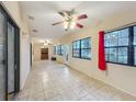 Spacious living area with tiled floors, large windows, and a view of the yard, complemented by a ceiling fan at 16621 Se 57Th Pl, Ocklawaha, FL 32179
