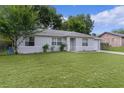 A cozy single-story home with a well-manicured lawn and mature trees at 18 Banyan Pass, Ocala, FL 34472