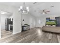 Open-concept living area with wood-look floors, modern ceiling fan, and ample natural light at 18 Banyan Pass, Ocala, FL 34472