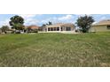 Large grassy backyard with a screened-in enclosure attached to the back of the house at 2002 Enrique Dr, Lady Lake, FL 32159