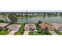 Gorgeous aerial view of a home, lake, and golf course community with lush greenery at 2002 Enrique Dr, The Villages, FL 32159