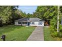 Inviting home with a long driveway, a green lawn, and vibrant blue accents at 2263 Moines Ct, Dunnellon, FL 34431