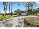 Wide driveway leading to a home with a two-car garage, stone accents, and a well-maintained lawn at 327 Se 50Th Ave, Ocala, FL 34471