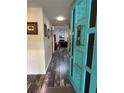 Welcoming entryway with wood-look floors, wainscoting, and a charming blue door at 3833 Ne 17Th Street Cir, Ocala, FL 34470