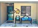Inviting front porch with decorative seating, a unique fish art piece, and stylish door at 3833 Ne 17Th Street Cir, Ocala, FL 34470