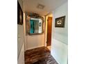 Hallway with a stylish mirror, wainscoting and wood-look flooring at 3833 Ne 17Th Street Cir, Ocala, FL 34470