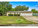 Home exterior featuring a spacious two-car garage and well-kept lawn at 4025 Ne 18Th St, Ocala, FL 34470