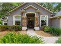 Inviting front entrance with stone accents and manicured landscaping enhancing curb appeal at 4465 Se 48Th Place Rd, Ocala, FL 34480