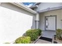 Inviting front entryway featuring a white door with glass panels and attractive landscaping at 5151 Sw 39Th St, Ocala, FL 34474