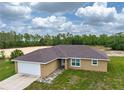 Single-story home featuring a two-car garage, a paved walkway, and a verdant, grassy lawn at 5331 Sw 121St Ter, Ocala, FL 34481