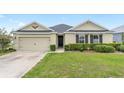 Inviting single-story home with a tidy front yard, two-car garage, and manicured hedges enhancing its curb appeal at 6646 Sw 64Th Ave, Ocala, FL 34476