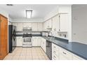 Functional kitchen featuring white cabinets, stainless steel appliances, and durable tile flooring at 8205 Sw 100Th Lane Rd, Ocala, FL 34481