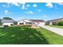 Exterior of a well-maintained home with a lush green lawn and tidy landscaping under a clear blue sky at 8554 Sw 63Rd Ct, Ocala, FL 34476