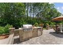 This outdoor kitchen features stainless steel grill, granite countertops and a seating area for entertaining at 9158 Sw 65Th Loop, Ocala, FL 34481