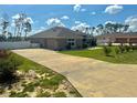 Wide driveway and partial lawn view, bordered by a white fence, and mature landscaping at 10405 Sw 47Th Ave, Ocala, Florida, FL 34476