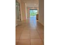 Hallway with tile flooring leading to a bright living area and sliding glass doors at 10584 Sw 91St Street Rd, Ocala, FL 34481
