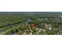Scenic aerial view of the property nestled among lush greenery with a nearby winding river at 12178 Palmetto Way, Dunnellon, FL 34432