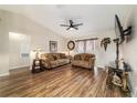 Comfortable living room featuring wood floors, ceiling fan, and ample seating at 1245 Nw 67Th Pl, Ocala, FL 34475