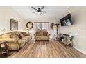 Comfortable living room featuring wood floors, ceiling fan, and ample seating at 1245 Nw 67Th Pl, Ocala, FL 34475