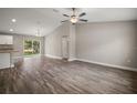 Spacious living room with vaulted ceiling, modern ceiling fan, and sliding glass doors at 134 Pine Course, Ocala, FL 34472