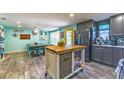 Open concept kitchen with gray cabinets, stainless appliances, and an island with butcher block countertop at 1404 Richmond Rd, Lakeland, FL 33801