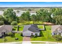 Aerial view of home featuring a well-maintained lawn, fenced backyard and stunning water views at 358 Irving Bend Dr, Groveland, FL 34736