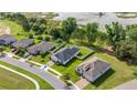 Aerial view of a single-story home featuring a solar panel roof, fenced backyard and a well-manicured lawn at 358 Irving Bend Dr, Groveland, FL 34736