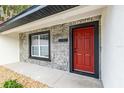Close up of the house number, a red door and stone facade at 6240 Cherry Rd, Ocala, FL 34472