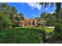 Beautiful home with mature landscaping, palm trees, and a well-manicured lawn at 695 Se 47Th Loop, Ocala, FL 34480