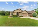 Charming single-story home featuring a manicured lawn, paver driveway, and neutral stucco exterior at 7839 Sw 97Th Cir, Ocala, FL 34481