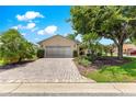 Charming single-story home with a brick driveway and lush, manicured landscaping at 8034 Sw 81St Loop, Ocala, FL 34476