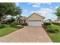 Attractive home with a brick driveway, two-car garage, and manicured landscaping at 8611 Sw 83Rd Loop, Ocala, FL 34481