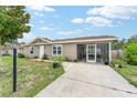 Inviting single-story home with neutral siding, white trim, a screened-in patio, and a well-maintained concrete driveway at 8940 Se 87Th Ter, Ocala, FL 34472