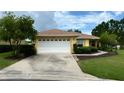 Charming single-story home with a well-manicured lawn, a two-car garage, and yellow paint at 9490 Sw 94Th Ct, Ocala, FL 34481