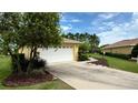 Charming single-story home with a well-manicured lawn, a two-car garage, and yellow paint at 9490 Sw 94Th Ct, Ocala, FL 34481