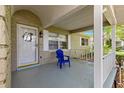 Inviting front porch with brick accents and a blue chair, perfect for relaxing outdoors at 9587 Sw 84Th Ter # E, Ocala, FL 34481