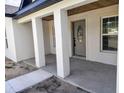 Inviting entryway with decorative front door, supported by 3 columns and nice ceiling details at 9721 Bahia Rd, Ocala, FL 34472